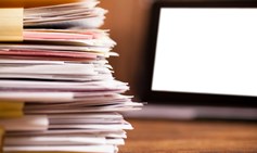 Large stack of files, paperwork. Desk, office, digital tablet